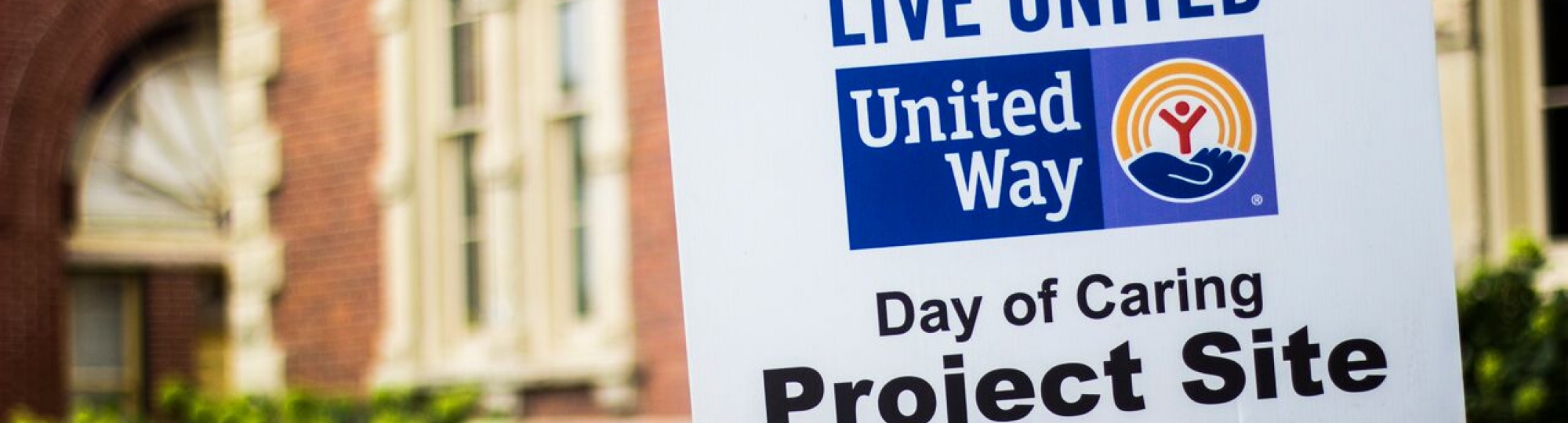 yard sign with wording "day of caring project site"